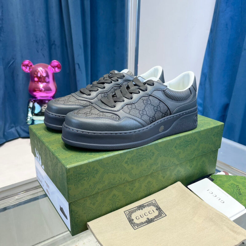 Scarpe Gucci nere su scatola verde, stile luxury con dettagli eleganti e decorazioni vivaci.