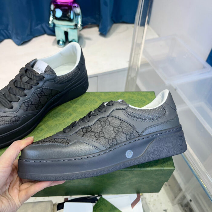 Scarpa da sneaker di lusso in pelle grigia con design minimalista e dettagli eleganti.