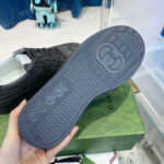 Sneaker Gucci con suola antiscivolo e logo iconico in ambiente retail di lusso.