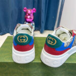 Sneaker Gucci con dettagli colorati e figura di orso rosa, stile moderno e di lusso.