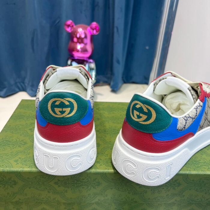 Sneaker Gucci con dettagli colorati e figura di orso rosa, stile moderno e di lusso.