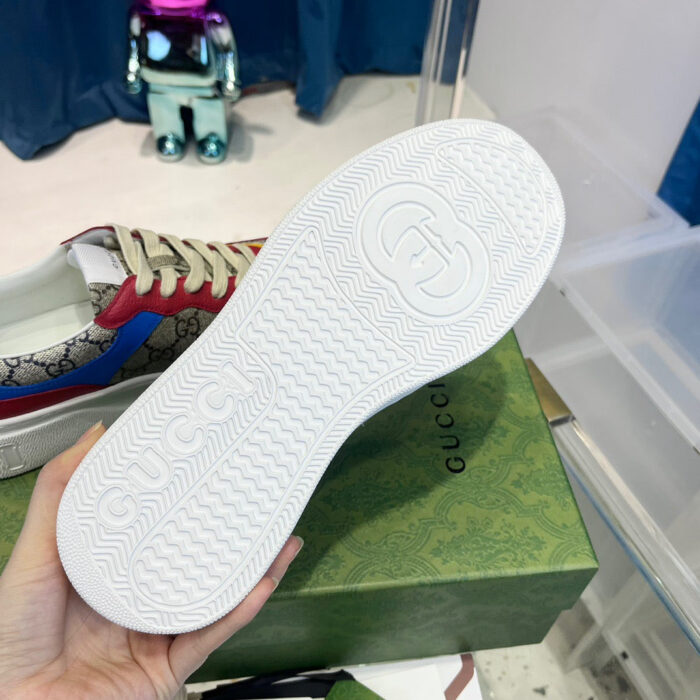 Sole sneakers Gucci con logo embossato, packaging elegante e dettagli di design di alta moda.