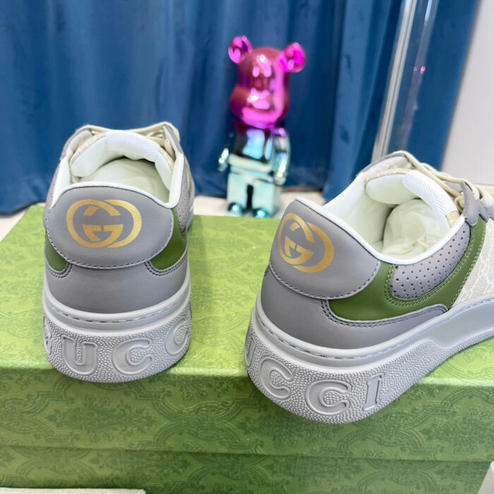Scarpe Gucci moderne con dettagli colorati e orso giocoso su sfondo blu.