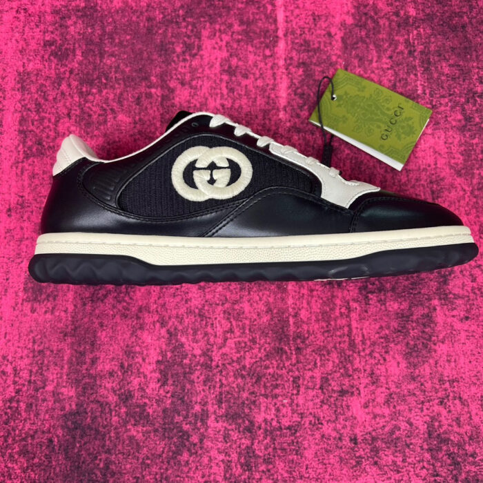Sneaker Gucci nera con logo doppio G e suola bianca, stile casual e di lusso.