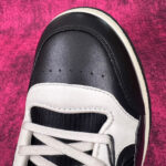 Sneaker elegante in nero e bianco con dettagli moderni e cuciture di alta qualità.