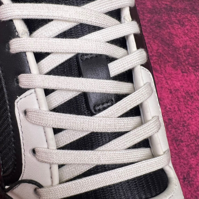 Sneaker moderna con lacci bianchi, dettagli black e su sfondo rosa vibrante.