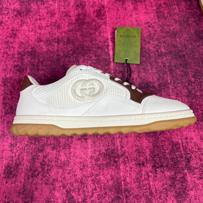Sneaker Gucci bianca con dettagli marroni, logo iconico e suola in gomma vintage.