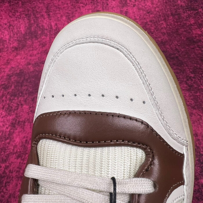 Sneaker elegante in pelle crema e marrone con dettagli di qualità e stile moderno.