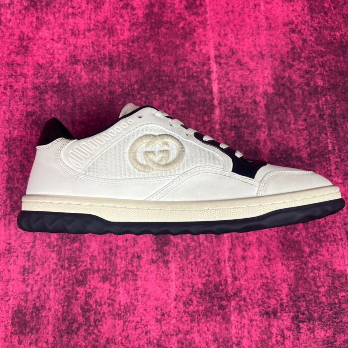Sneaker bianca di lusso con logo doppio G e dettagli eleganti su sfondo rosa vivace.