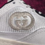Sneaker di lusso in materiali metallizzati con logo embossato, dettagli eleganti e design contemporaneo.