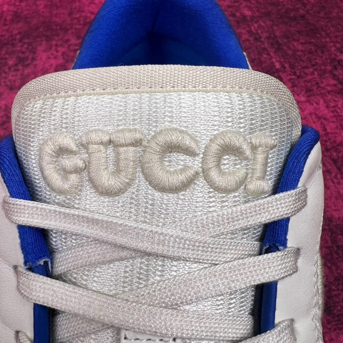 Sneaker Gucci bianca con ricamo logo, dettagli eleganti e design moderno e lusso.