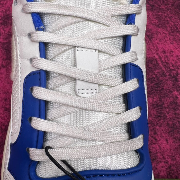 Sneaker bianca sportiva con dettagli blu, tessuto traspirante e design moderno.