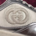 Sneaker di lusso con logo G Gucci e dettagli metallici per uno stile elegante e moderno.