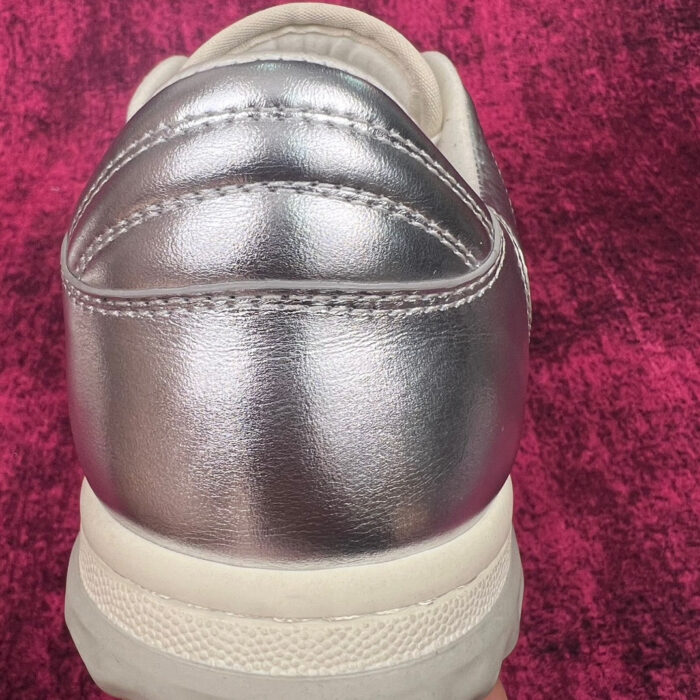 Sneaker moderna con design metallizzato, dettagli di cuciture eleganti e suola resistente.
