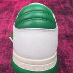 Sneaker bianca con dettaglio verde, design moderno, per sport e casual in stile energico.