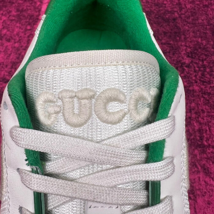 Sneaker Gucci bianca con dettagli verdi e ricamo elegante sul fronte.