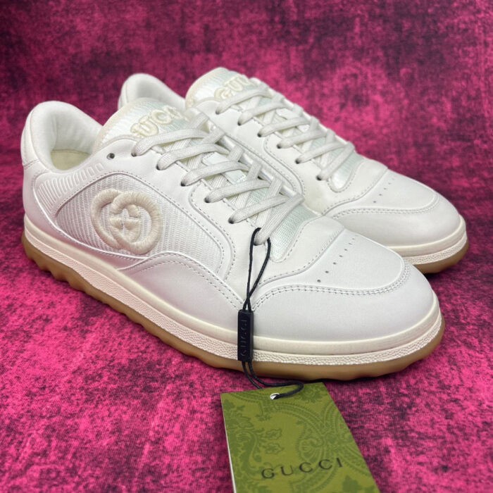 Sneakers Gucci bianche, stile moderno, lusso, design minimalista, suola in gomma, logo embossed.