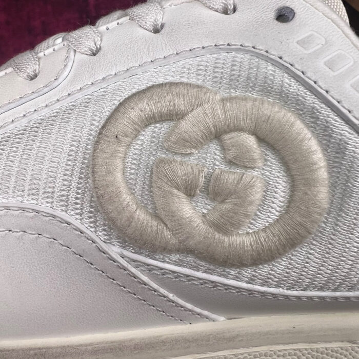Sneaker Gucci bianca con logo Ricamato, stile sportivo e dettaglio di lusso raffinato.
