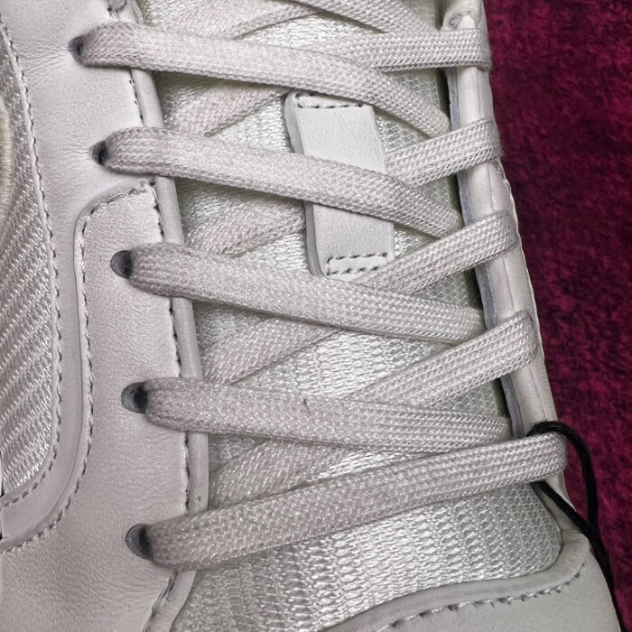Scarpa bianca con lacci, dettagli in tessuto, sfondo viola elegante e moderno.