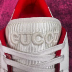 Sneaker Gucci bianca in pelle con dettagli di lusso e interno rosso vibrante.