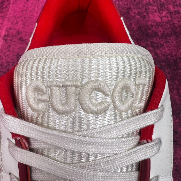 Sneaker Gucci bianca in pelle con dettagli di lusso e interno rosso vibrante.