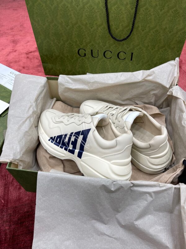 Scarpe Gucci di lusso in scatola elegante su tappeto rosso, stile e qualità premium