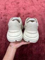 Scarpe sportive in crema su sfondo marrone, stile elegante e comfort massimo, dettagli di lusso.