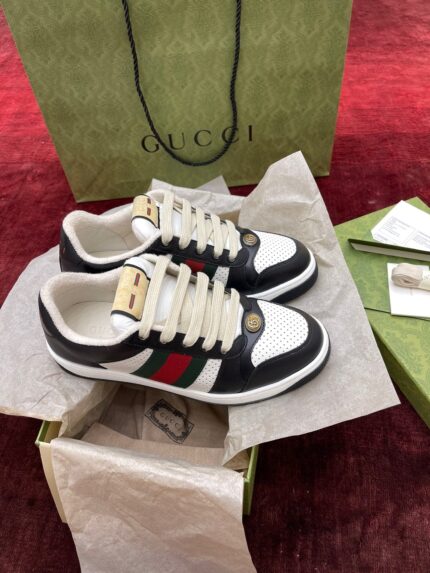Scarpe Gucci di lusso con packaging elegante e dettaglio iconico verde e rossa.