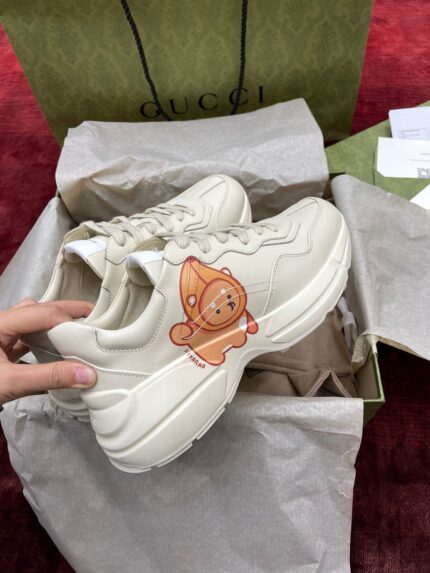 Sneakers Gucci beige con personaggio giocoso, packaging elegante e stile moderno di lusso