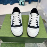 Sneakers bianche e navy su scatola verde, stile moderno e chic per outfit casual.