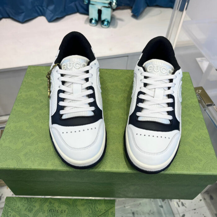 Sneakers bianche e navy su scatola verde, stile moderno e chic per outfit casual.