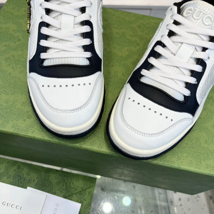 Sneakers di lusso bianco e blu su scatola verde texture, stile sportivo raffinato, dettagli attentamente cuciti.