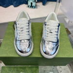 Sneakers metalliche argentate su scatola verde, stile moderno e trendy per look fashion.