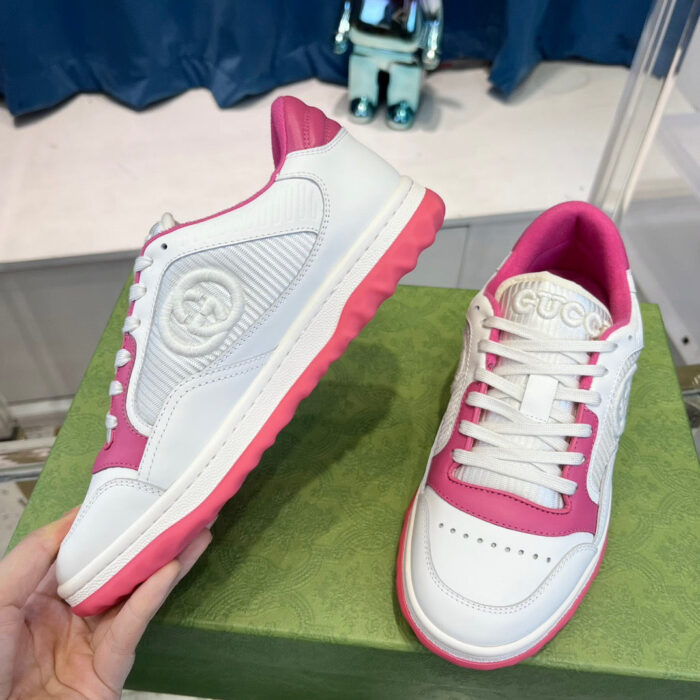 Sneakers sportive bianche e rosa su scatola verde, stile moderno e dettagli eleganti.