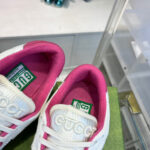 Sneakers Gucci bianche con fodera rosa e packaging verde, stile lussuoso e alla moda.
