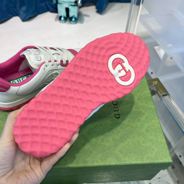 Sneaker di lusso con suola rosa, logo in evidenza e dettagli moderni.