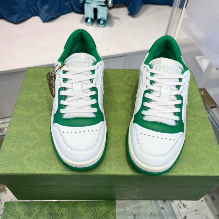 Sneakers bianche e verdi su scatola elegante, stile sportivo e moderno.