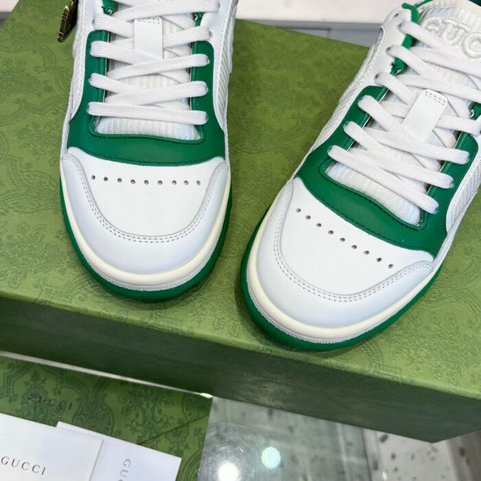 Sneaker uomo bianca e verde, design moderno e dettagli di qualità su scatola elegante.