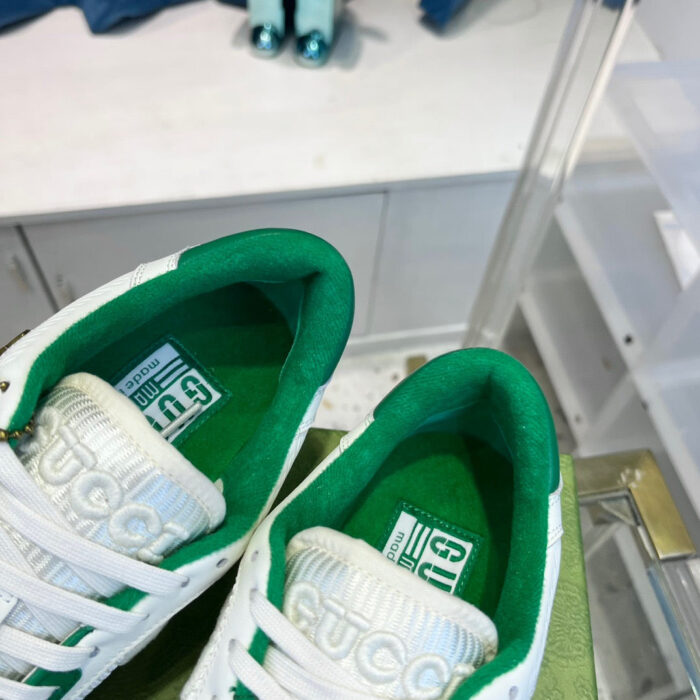 Sneakers bianche eleganti con dettagli verdi, stile moderno e comfort ideale per ogni outfit.