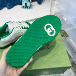 Sneaker di lusso con suola verde brillante e design elegante in stile casual.