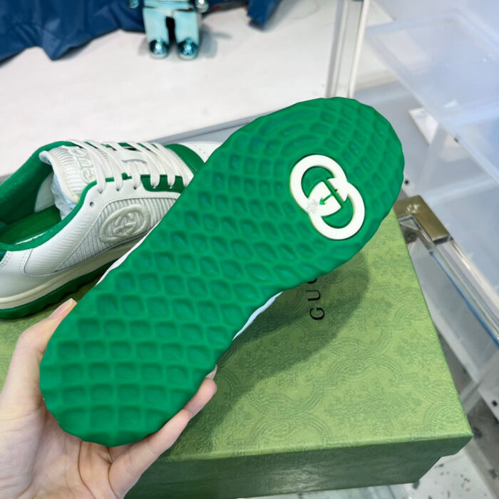 Sneaker di lusso con suola verde brillante e design elegante in stile casual.