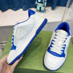Sneakers bianco e blu alla moda su sfondo verde con dettagli moderni e comfort garantito.