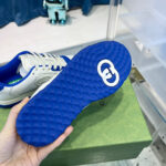 Sole di sneaker blu con logo bianco e design moderno, in mostra su sfondo stilizzato.