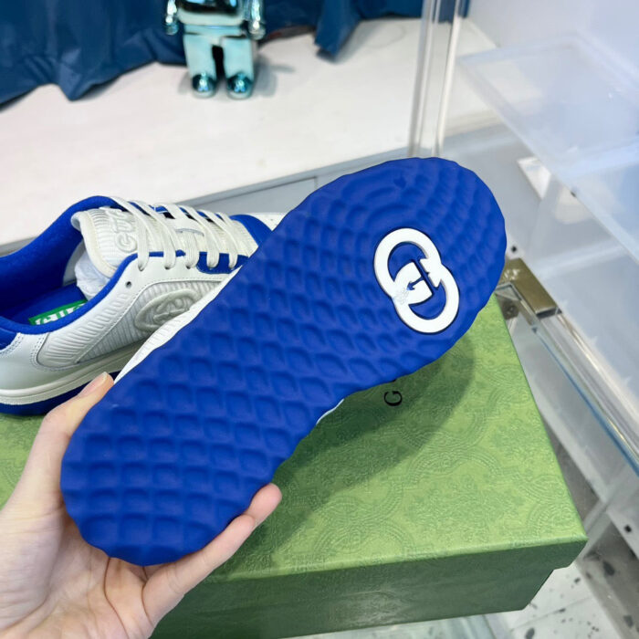 Sole di sneaker blu con logo bianco e design moderno, in mostra su sfondo stilizzato.