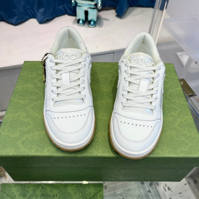 Sneakers bianche di design su scatola verde elegante, stile moderno e raffinato.