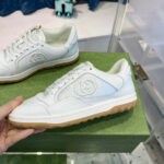 Scarpe sportive bianche di alta qualità su pedestale verde in boutique elegante.