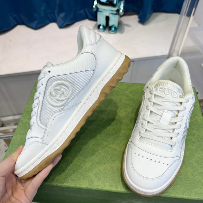 Sneakers bianche con suola in gomma gialla fluo su display moderno, stile casual e trendy.