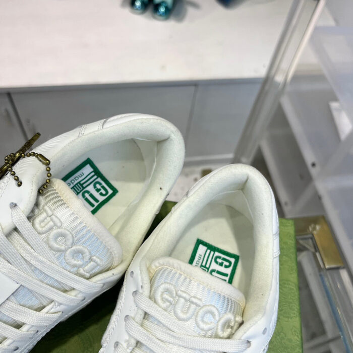 Sneakers bianche di lusso con dettagli eleganti e charms, ideali per uno stile moderno e raffinato.