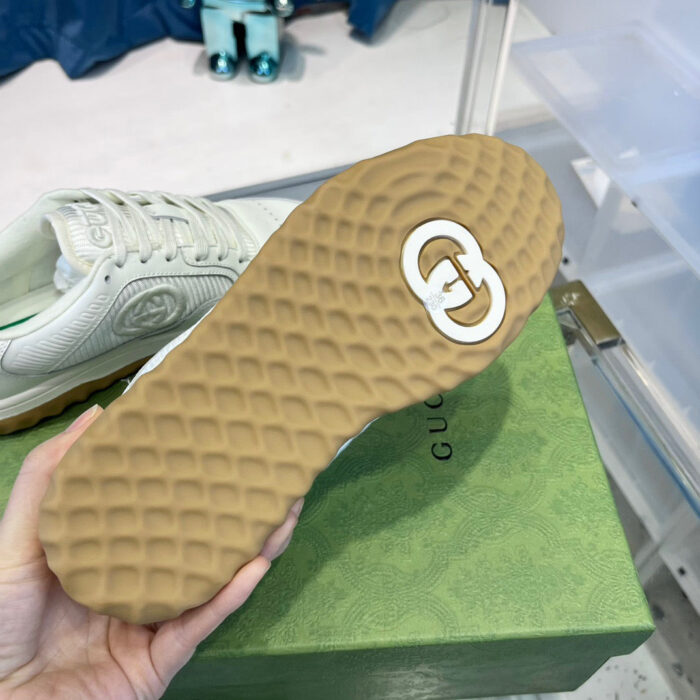 Sneaker di lusso con suola in gomma, logo glossy e design moderno elegante.