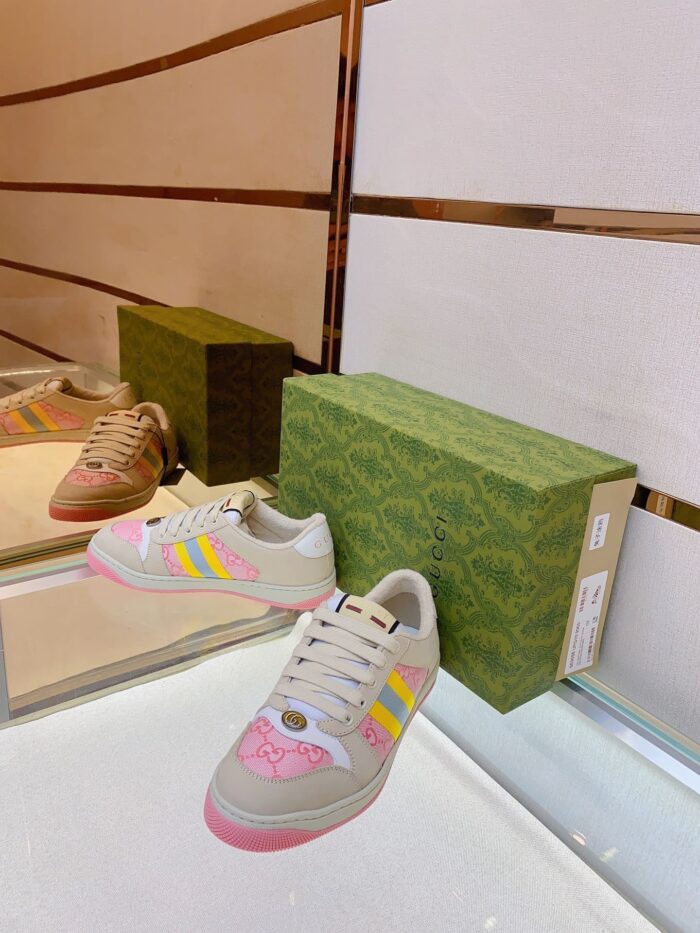 Scarpa sneakers colorata e moderna con elegante packaging verde, su superficie riflettente e sfondo minimal.